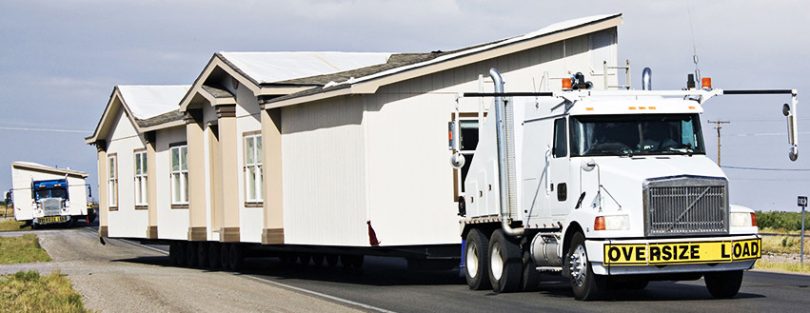 Trucks moving mobile homes