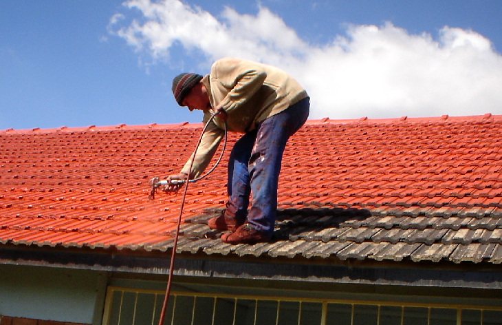 Spraying sealant on roof